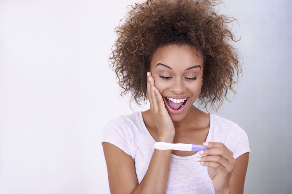 Happy woman with pregnancy test
